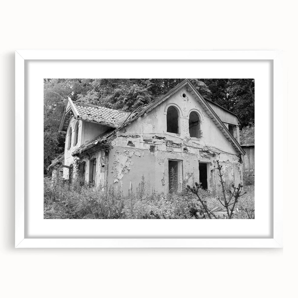 Abstract art print featuring geometric shapes in muted gray and blue tones, framed with a white mat.