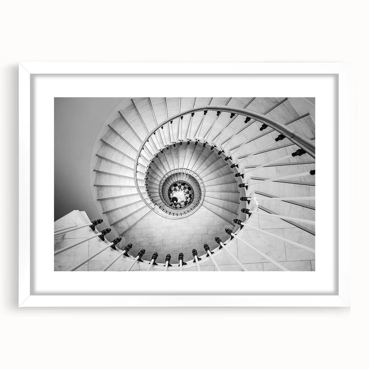 Abstract art print of a spiral staircase in monochrome, framed with a white mat.