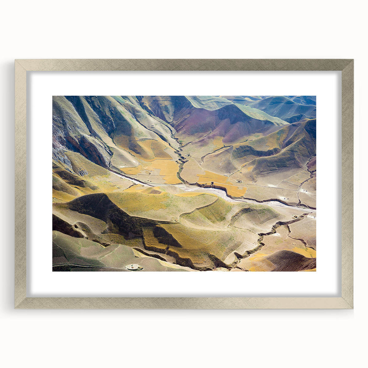 Textured abstract art print depicting a muted Middle Eastern scenery, framed in silver, ideal for bedroom decor.