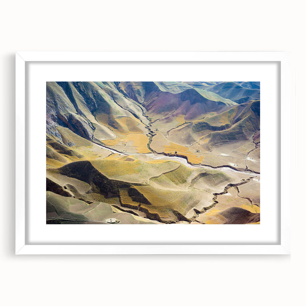 Abstract art print depicting a Middle Eastern landscape in muted earth tones, framed with a white mat.