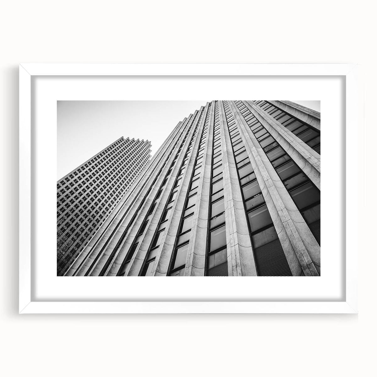 Abstract art print of Houston skyline in muted blue and gray tones on a framed white mat, ideal for dining room decor.
