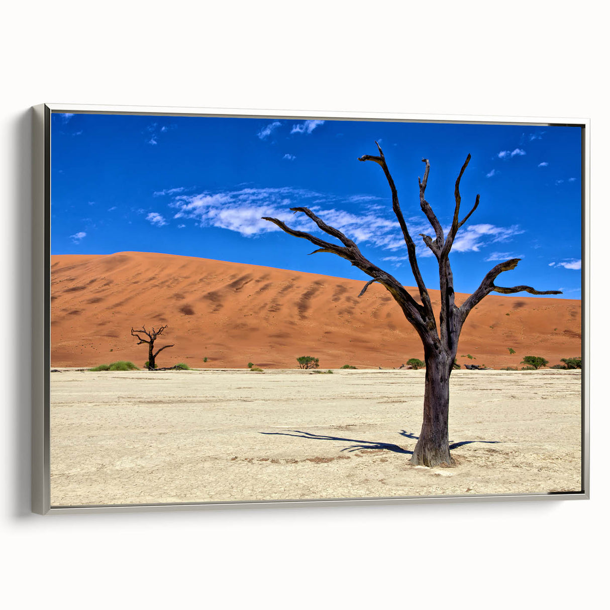 Vintage poster art of a Namibian landscape on a framed canvas, featuring a silver frame and a color palette of earth tones.