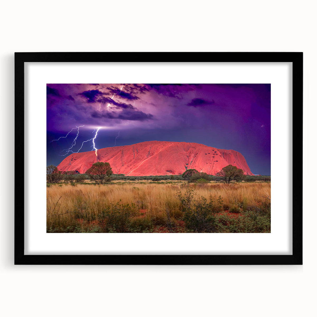 Abstract art print of Ayers Rock in vibrant orange and red hues on a black framed canvas, suitable for living room decor.