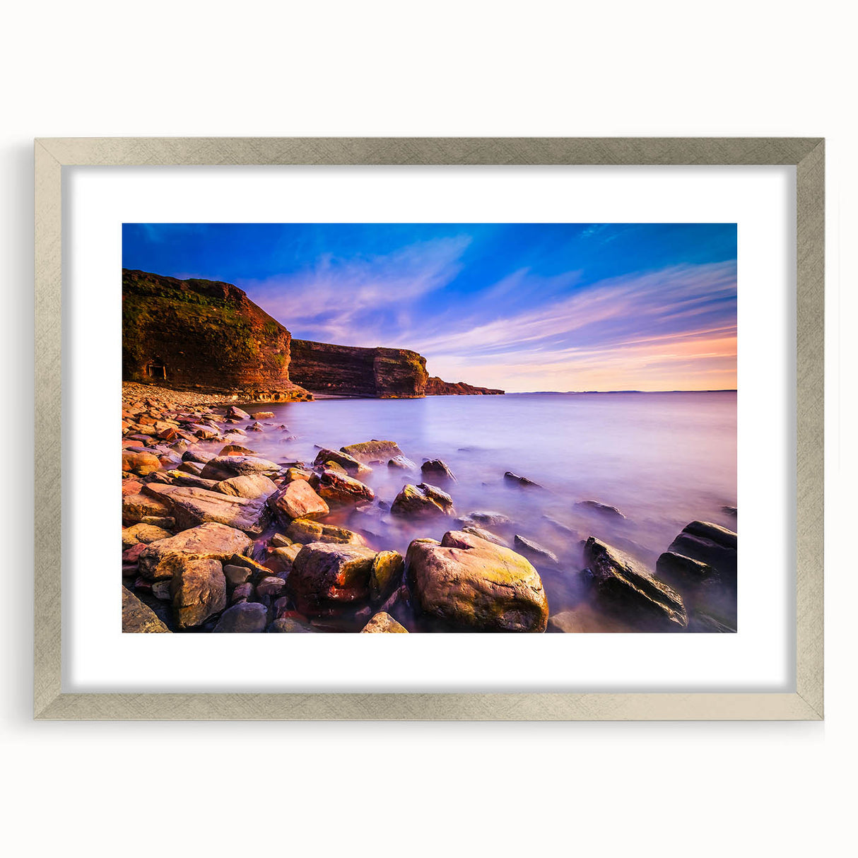 Abstract art print of Newfoundland scenery in muted blue and green tones, framed with a silver mat.
