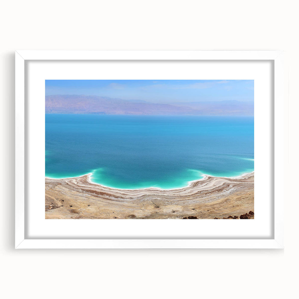 Abstract art print of the Dead Sea in muted blue and beige tones, framed with a white mat, suitable for dining room decor.