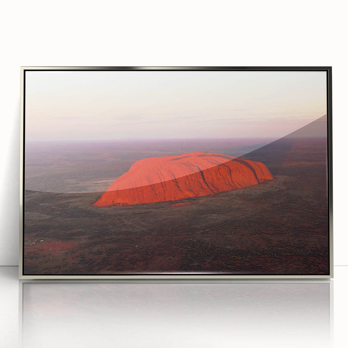 Acrylic print of Ayers Rock in silver frame, featuring earthy red and orange tones, suitable for modern art wall decor.