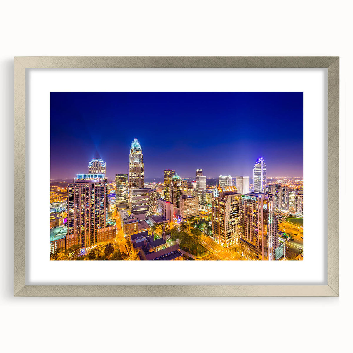Textured abstract art print of Charlotte skyline in muted blue and gray, framed in silver, suitable for bedroom decor.