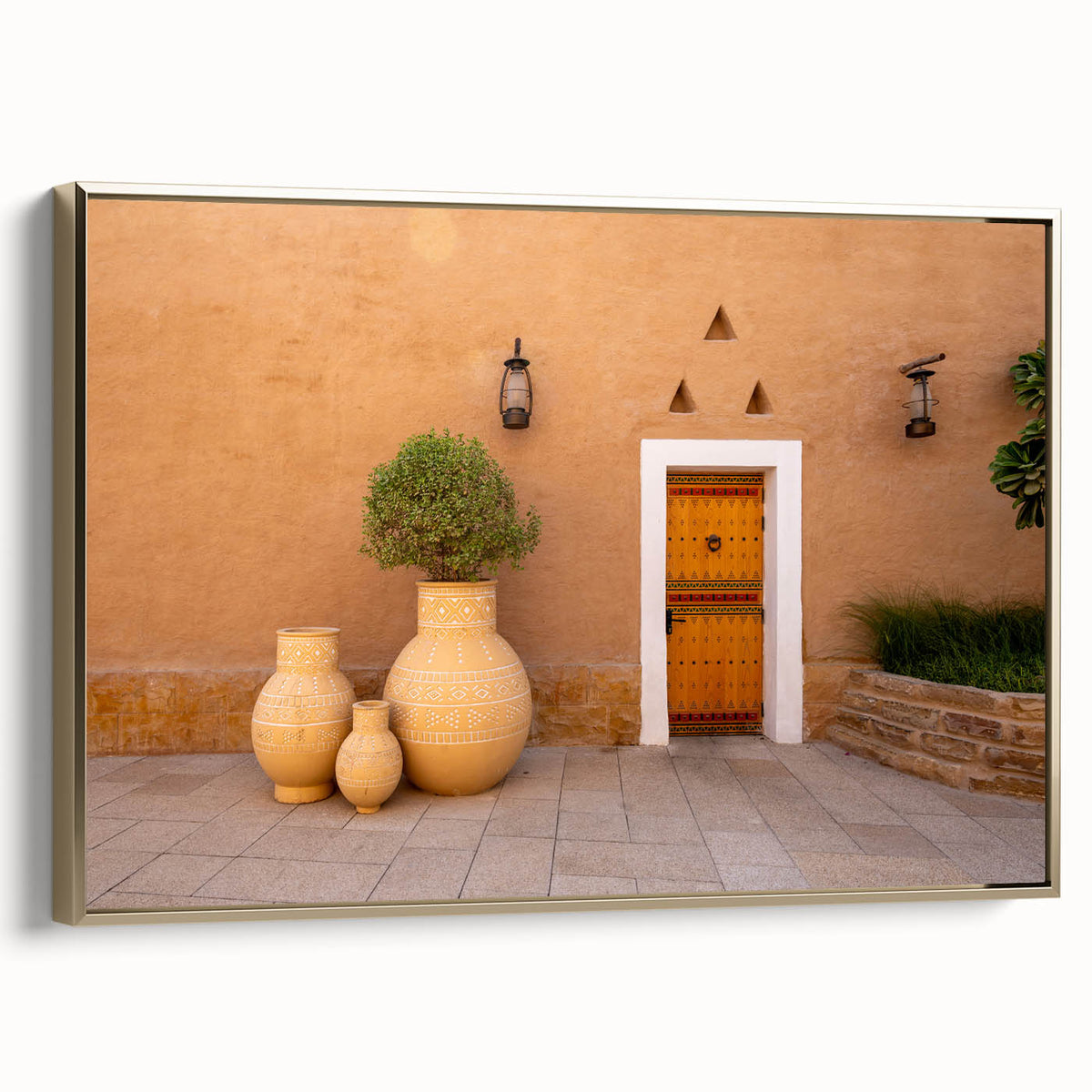 Framed canvas wall art depicting a vintage-style landscape of Saudi Arabia in muted gold and black tones.