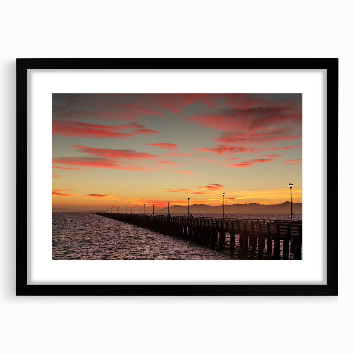 Abstract art print of colorful, textured scenery, set in a large black frame with mat, suitable for living room decor.