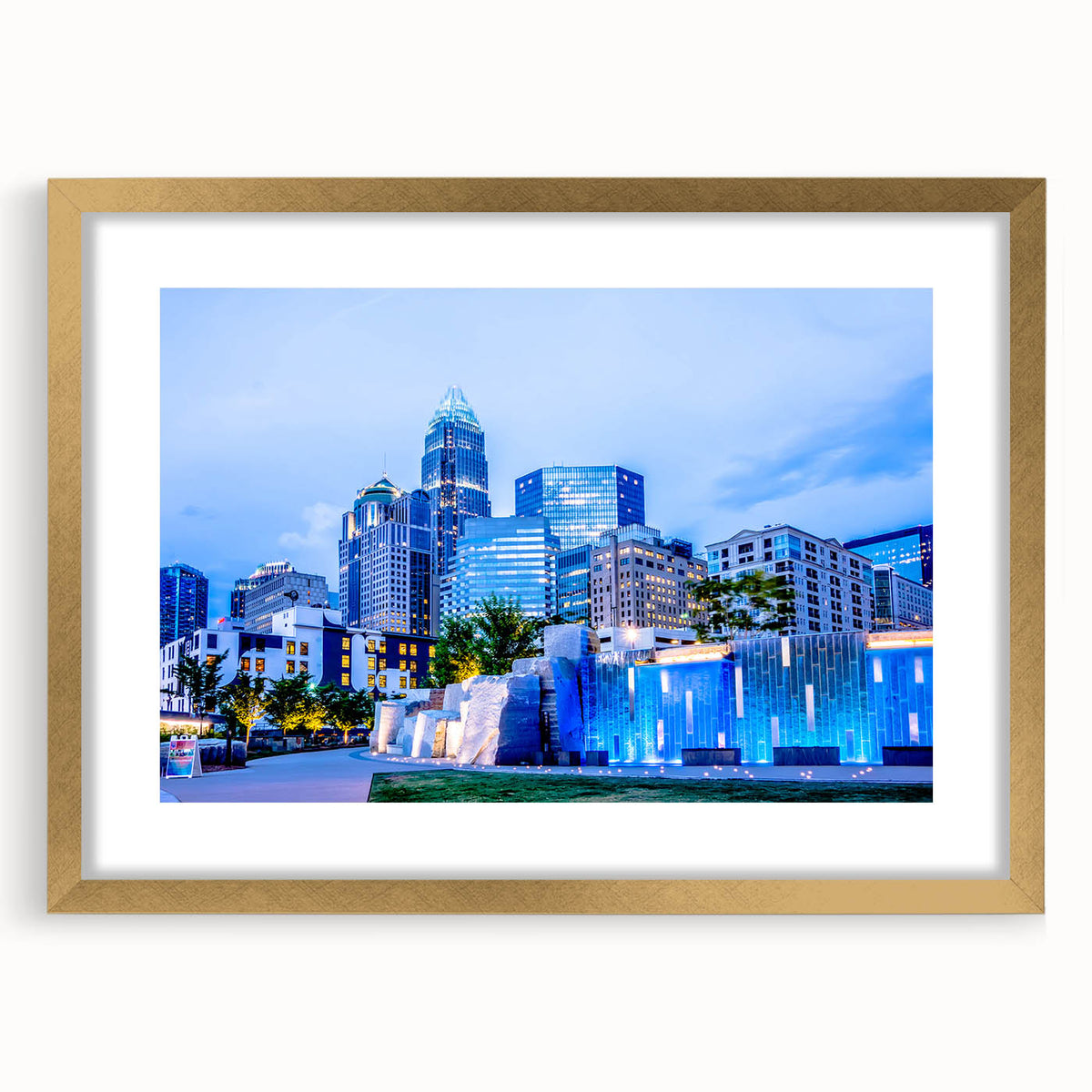 Abstract art print of Charlotte skyline in muted gray and blue tones on a gold-framed canvas, ideal for living room decor.
