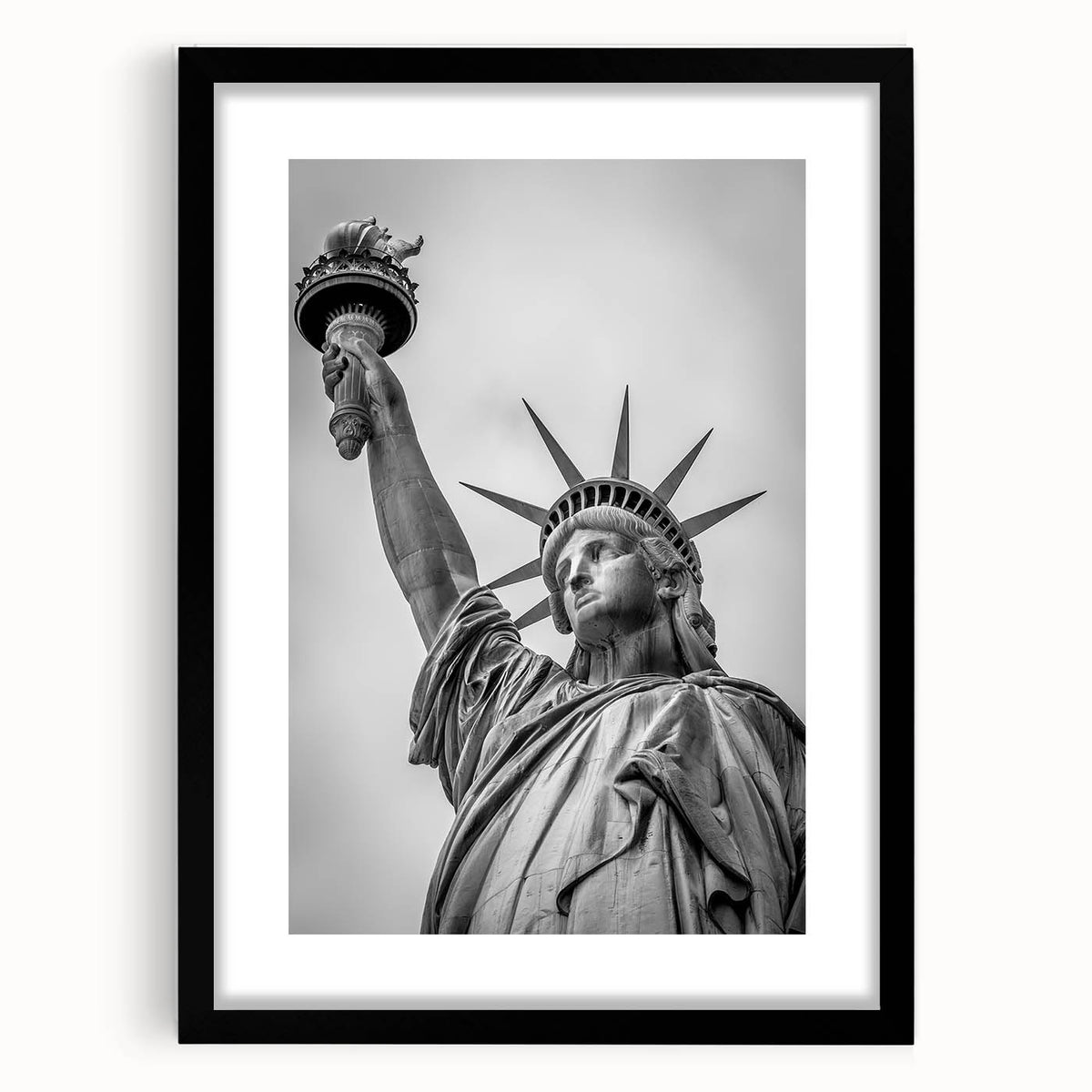 Abstract art print of the Statue of Liberty in muted green and blue tones on a framed black mat.