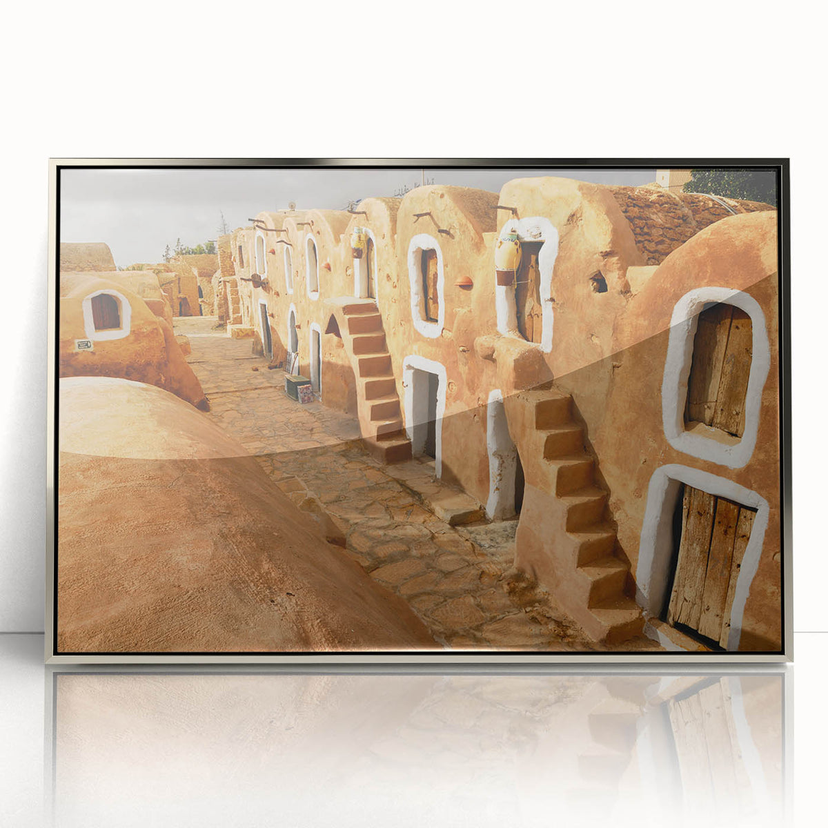 Mid-century modernist art depicting a Tunisian landscape in muted earth tones, framed in silver acrylic.