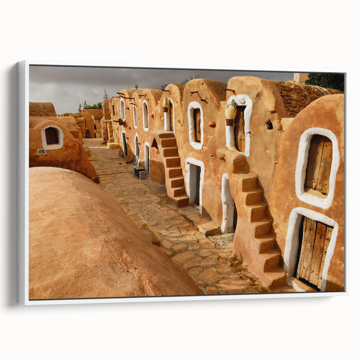 Vintage poster art of a Tunisian landscape on framed canvas, featuring vibrant colors against a black background.
