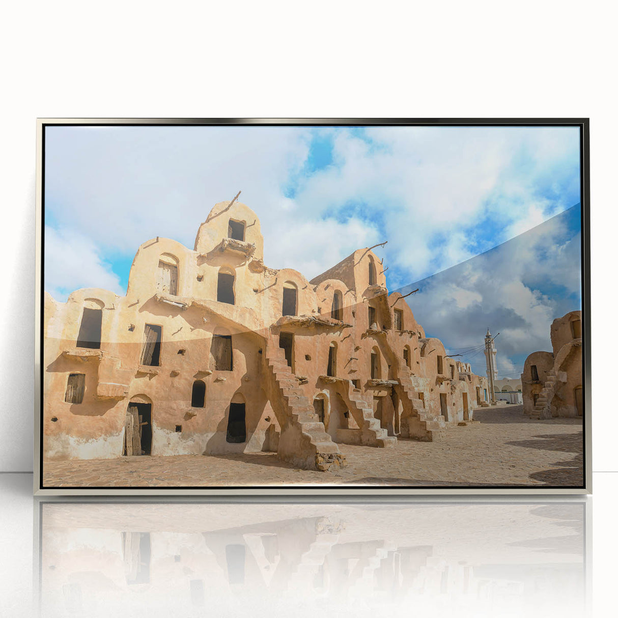 Mid-century modernist art depicting a Tunisian landscape in muted earth tones on a silver-framed acrylic print.