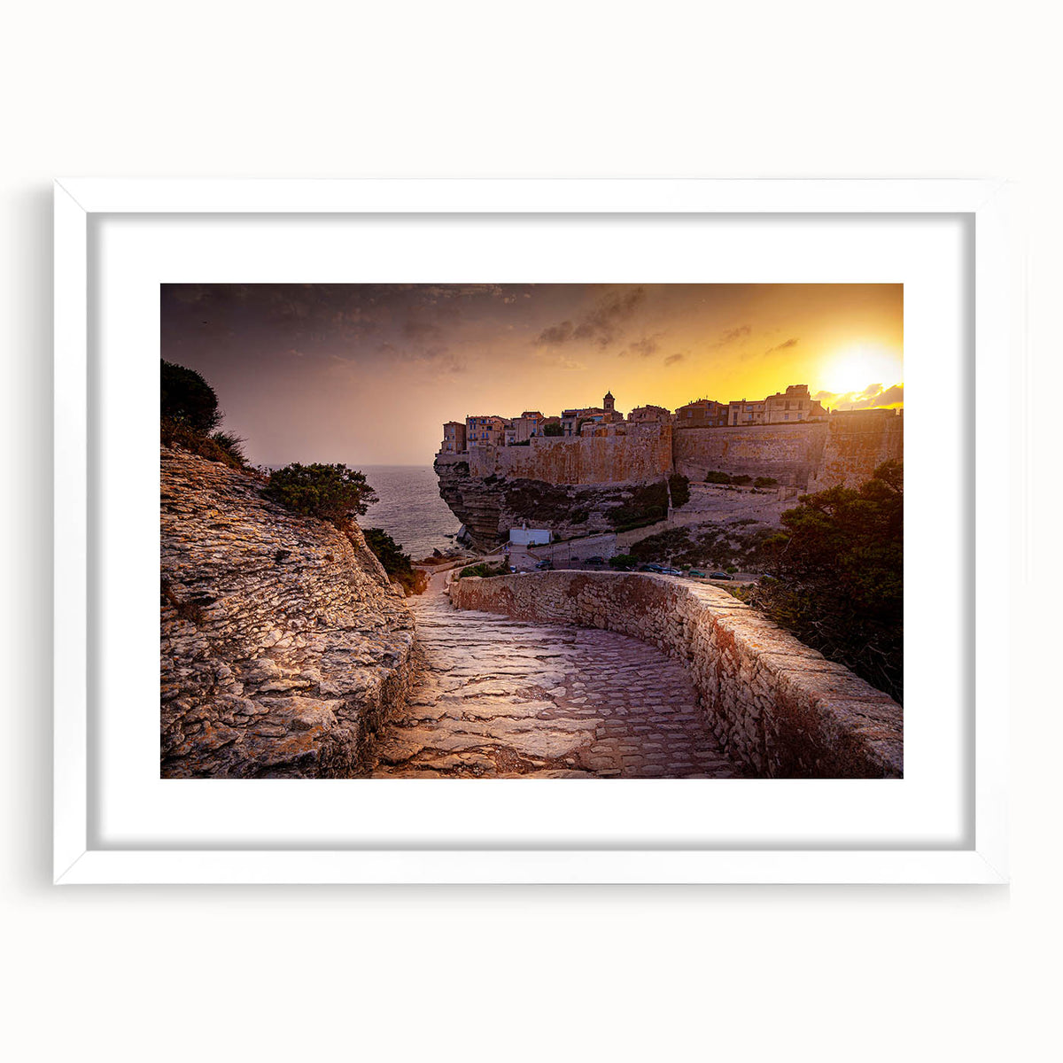Textured abstract art print of Corsican scenery in muted earth tones on a framed white mat, ideal for bedroom wall decor.