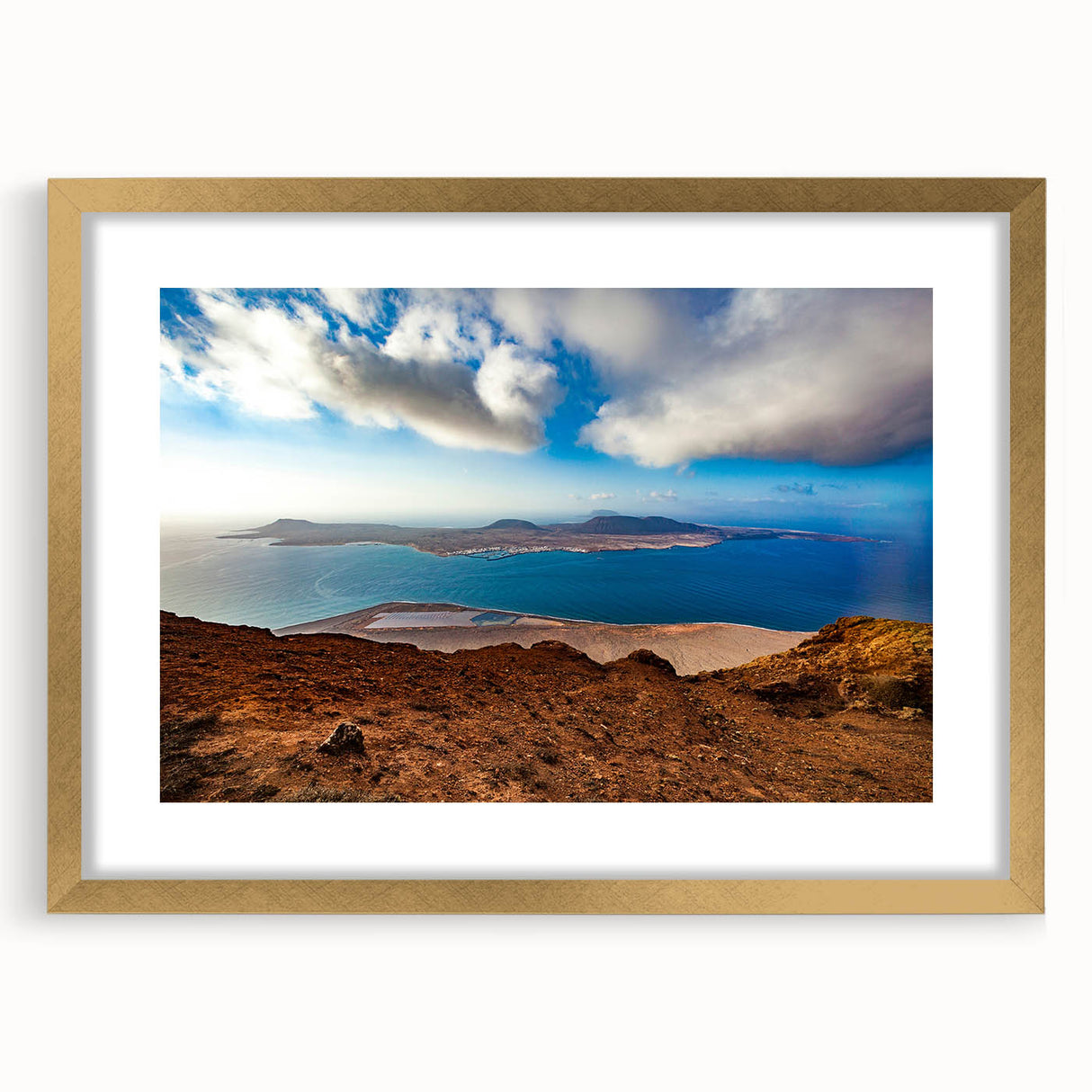 Abstract art print of a European scenery in muted gold and blue tones, framed with a gold mat.