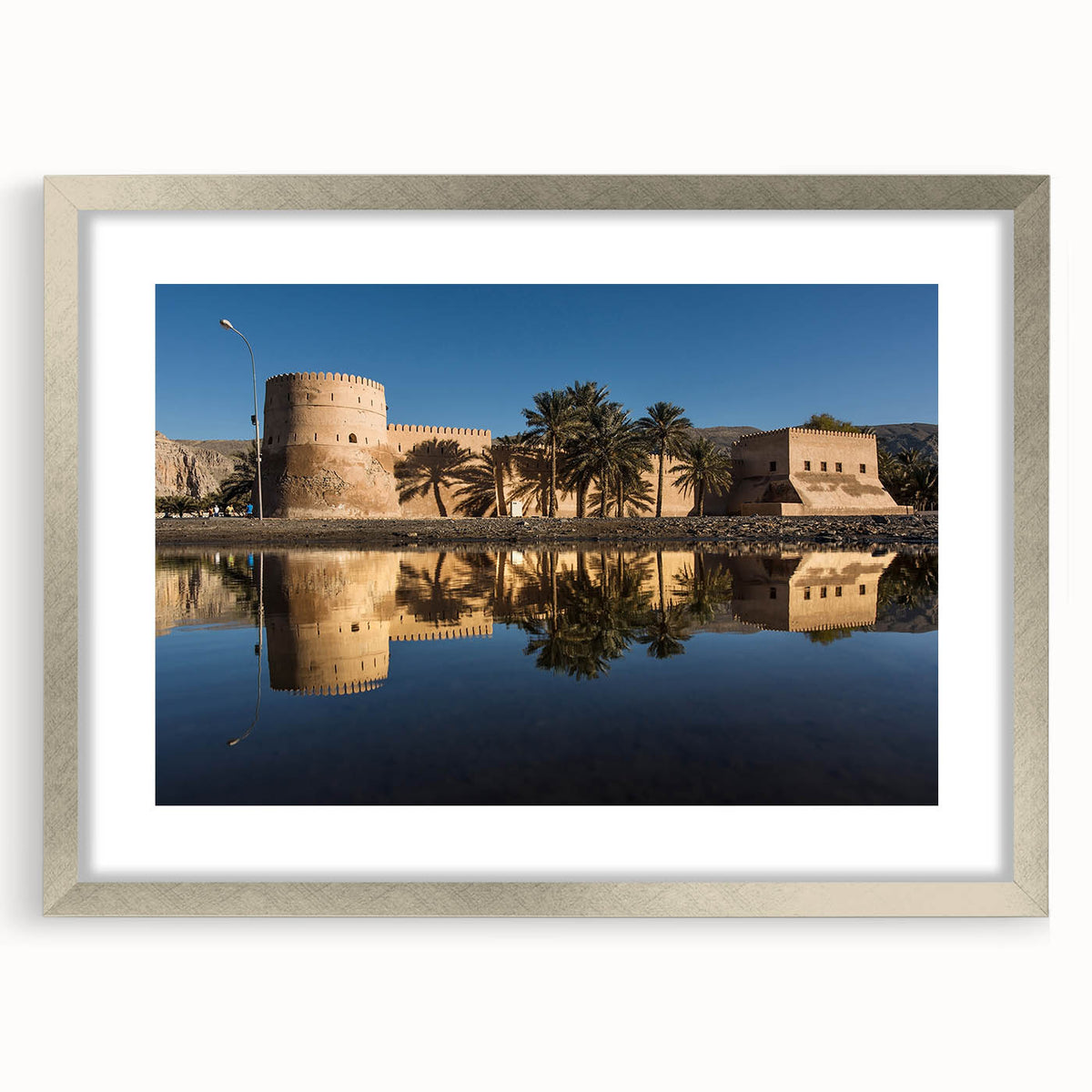 Textured abstract art print of Oman scenery in muted earth tones, framed with a silver mat, suitable for bedroom wall decor.