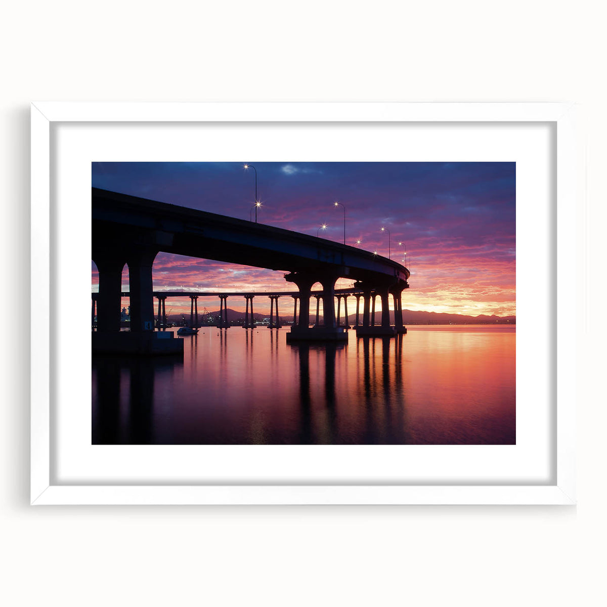 Abstract art print depicting the Coronado, California skyline in muted blue and gray tones on a framed white mat.
