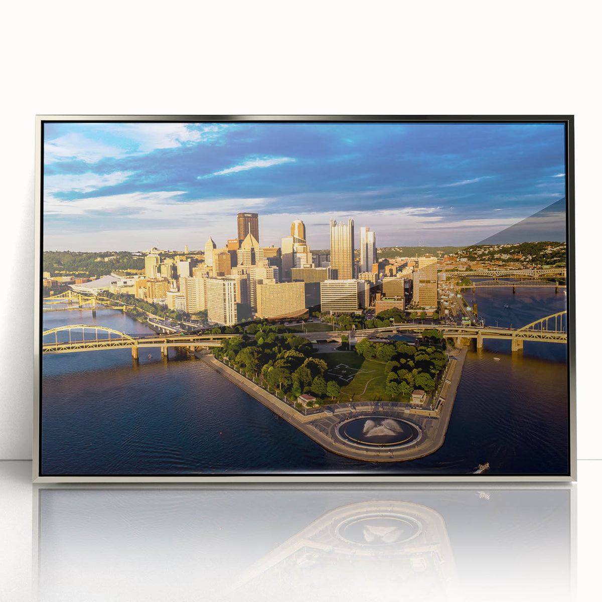 Mid-century modernist art depicting the Pittsburgh skyline in muted gray and blue tones on a silver-framed acrylic print.