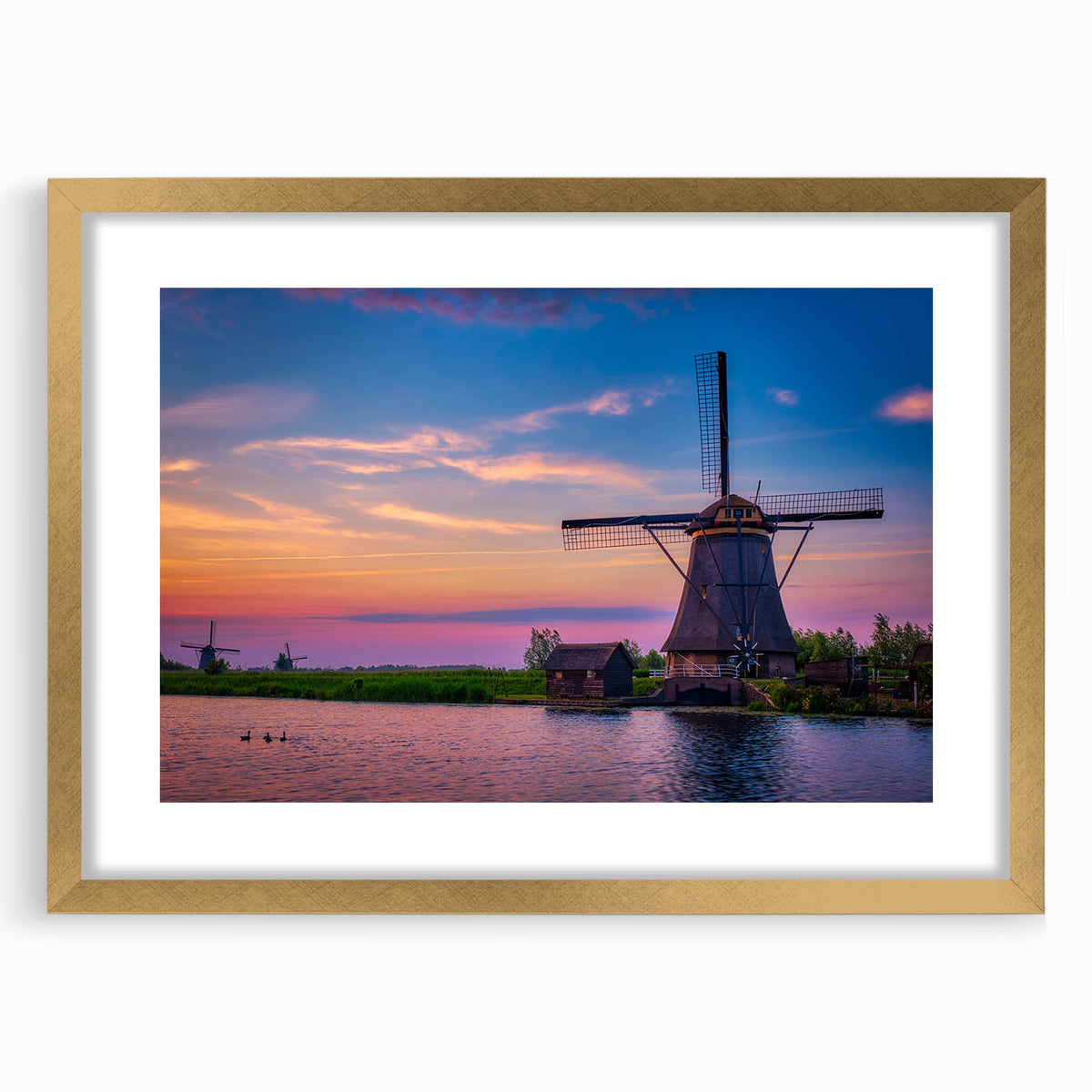 Abstract art print of a European scenery in muted gold and blue tones, framed with a gold mat.