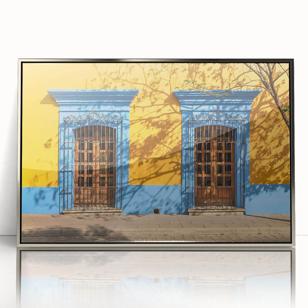 Mid-century modernist art depicting Oaxaca scenery in muted earth tones on a silver-framed acrylic.