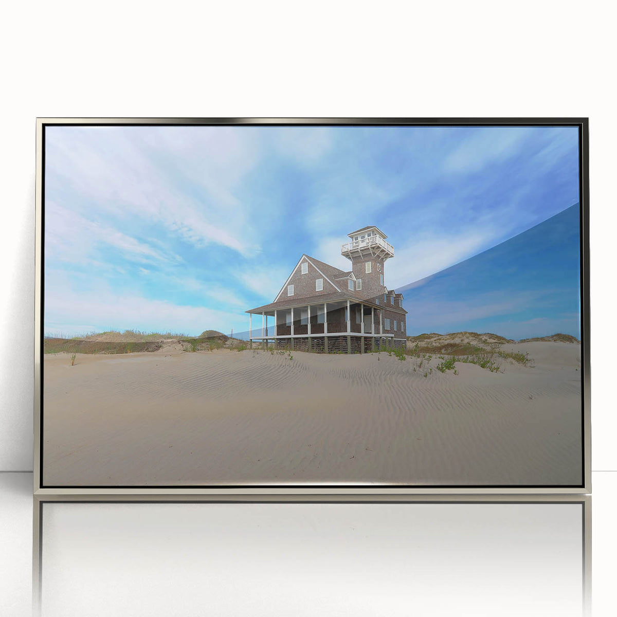 Mid-century modernist art depicting the Outer Banks, North Carolina in muted blue and green tones on a silver-framed acrylic.