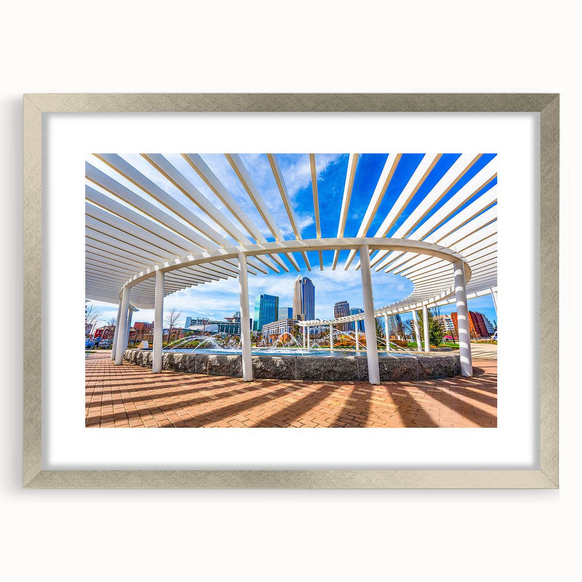 Textured art print of Charlotte skyline in muted grays and blues on a framed silver mat, suitable for bedroom decor.