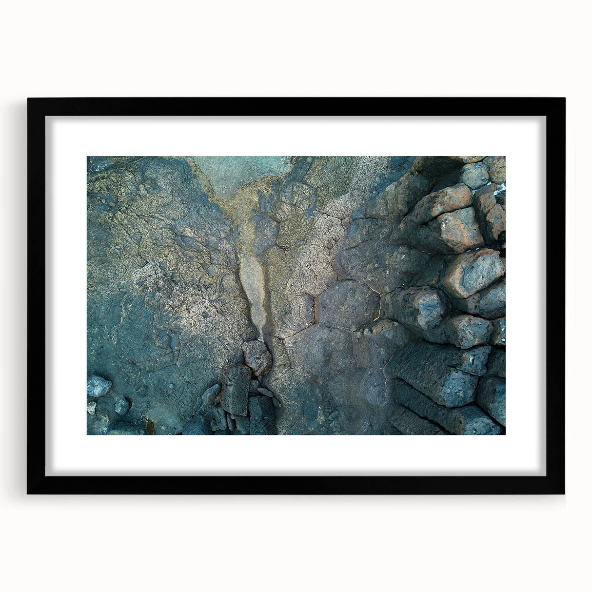 Extra large abstract art print of colorful, textured scenery resembling the Canary Islands, in a black frame with mat.
