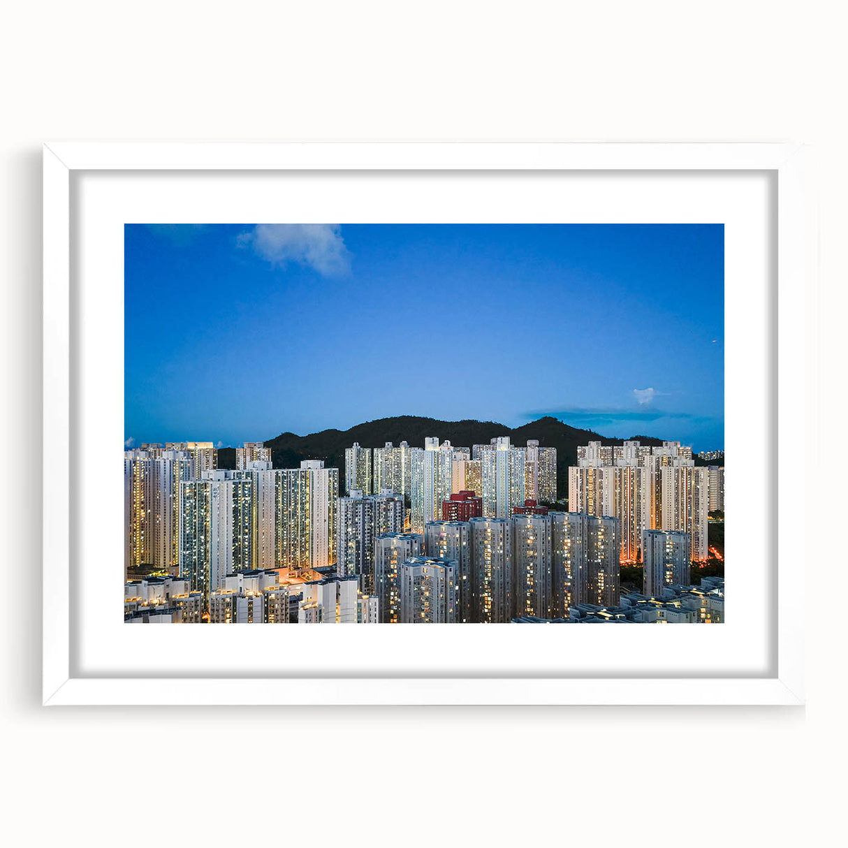 Abstract art print of Hong Kong skyline in muted gray and blue tones on a framed white mat.