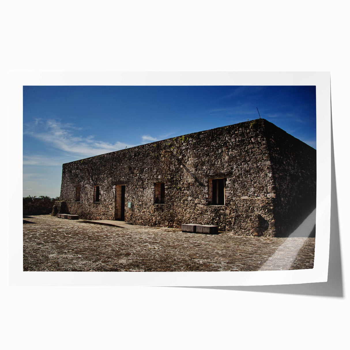 Rolled print of Quintana Roo scenery featuring lush greenery and a calm lake, in muted earth tones.