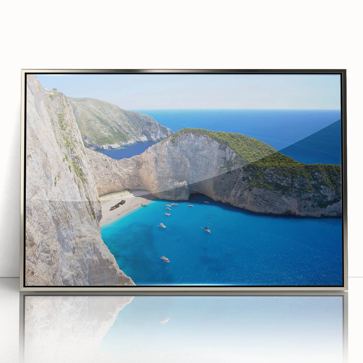 Framed wall art featuring a serene beach landscape with soft waves and a sunset in silver-accented frame, perfect for coastal-themed decor.