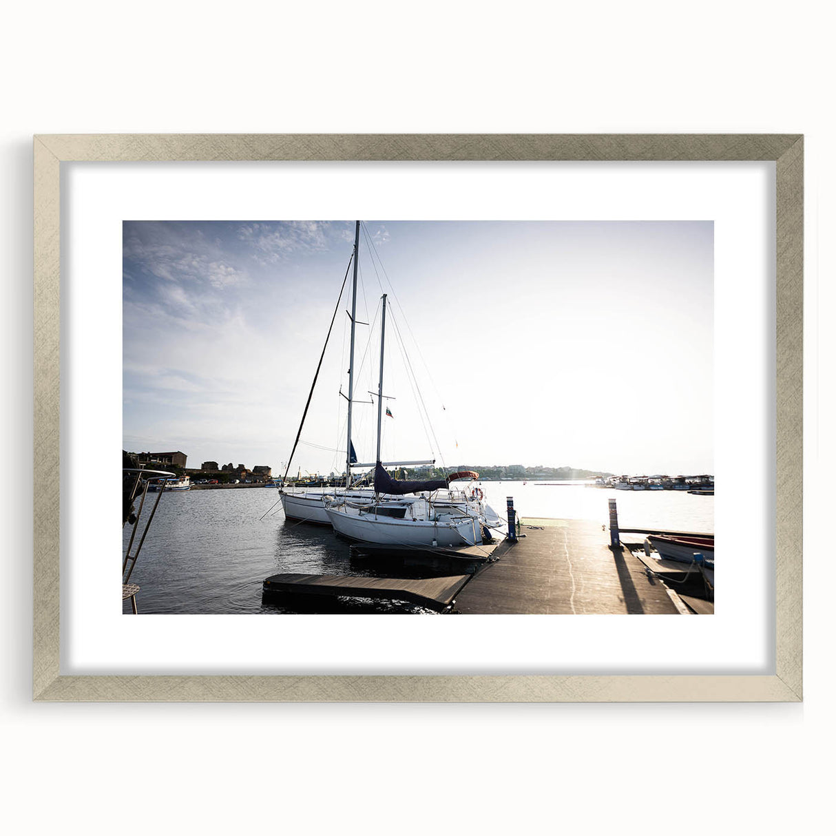 Framed wall art of a serene harbor landscape design in silver frame with mat, showcasing calming blues and greens, perfect for home décor and relaxation.