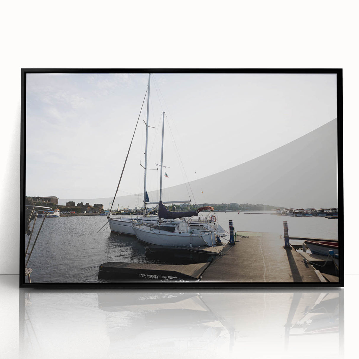 Framed acrylic wall art featuring a serene harbor landscape design, with a sleek black frame, perfect for coastal-themed home decor. Ideal for enhancing living spaces.