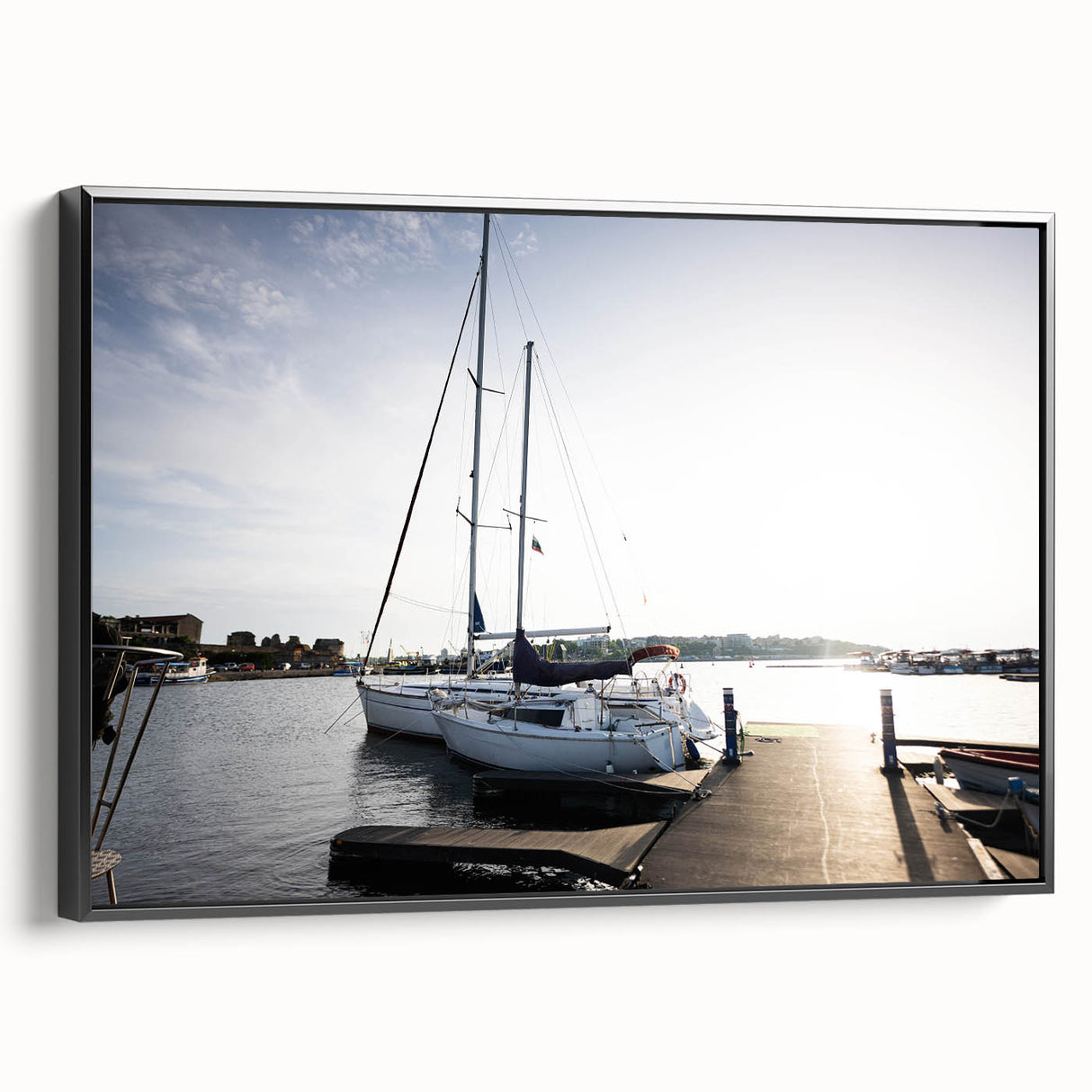 Framed canvas wall art showcasing a serene harbor landscape with vibrant colors and intricate details, set against a sleek black frame, ideal for home decor.