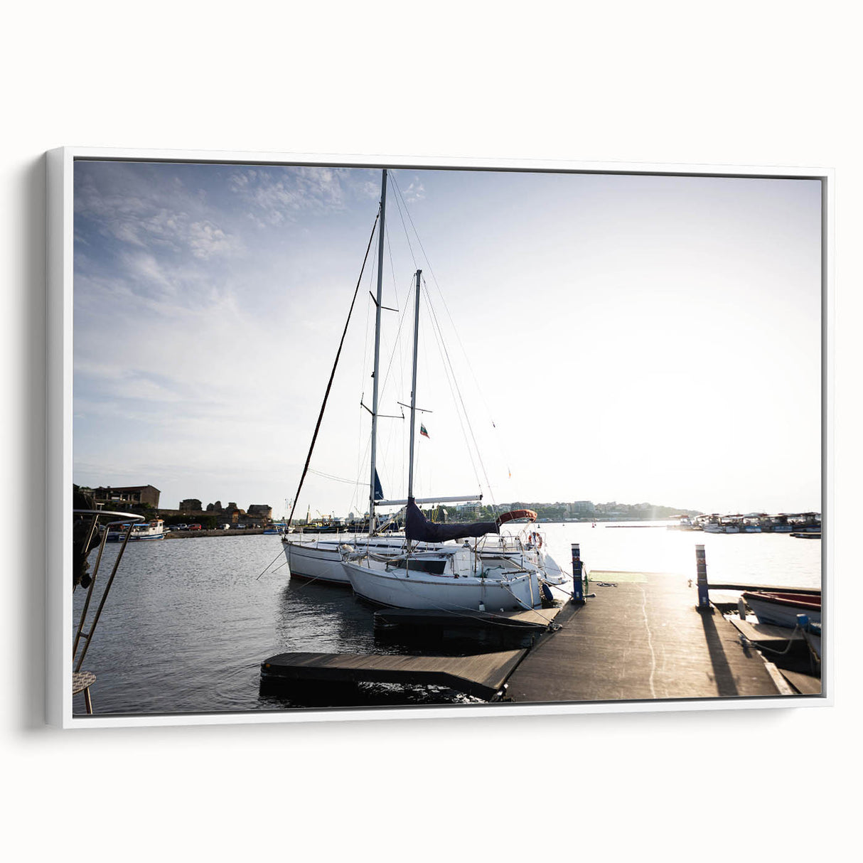Framed canvas wall art showcasing a serene harbor landscape design, featuring soft blues and greens, with a sleek white frame enhancing its elegance. Perfect for home decor.