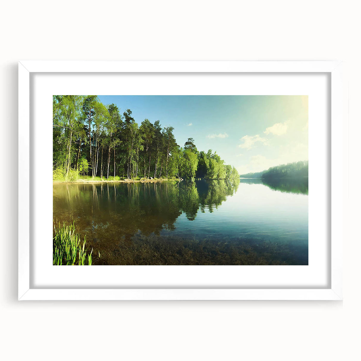 Framed wall art featuring a serene landscape of a tranquil lake surrounded by lush greenery, presented in a white mat and frame, ideal for home decor.