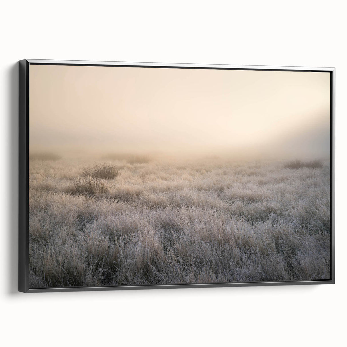 Framed canvas wall art depicting a serene landscape enveloped in mist, featuring soft gray and white tones with a sleek black frame, ideal for modern decor.