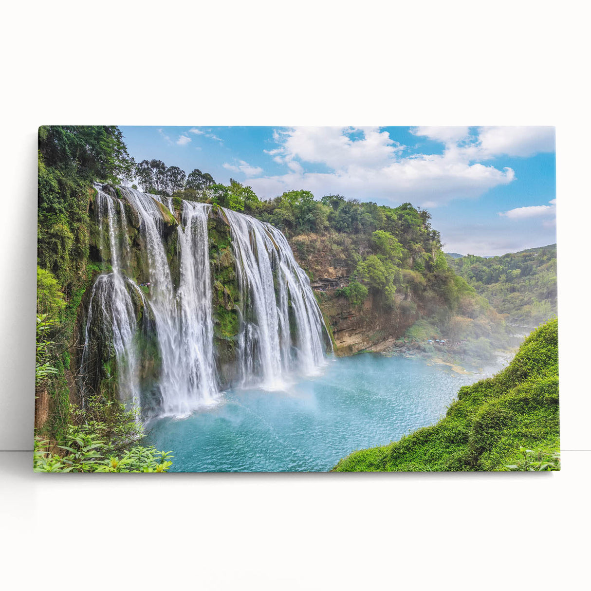 Stretched canvas artwork depicting a serene landscape with cascading waterfalls, lush greenery, and vibrant colors, ideal for home decor and nature enthusiasts.