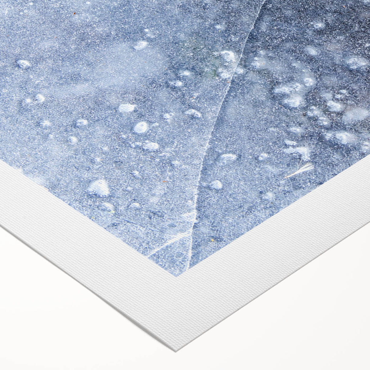 Art deco poster featuring a close-up of frost patterns in muted blue and white tones on rolled canvas.