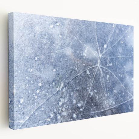 Close-up image of frost patterns on a stretched canvas, featuring intricate white and blue designs.
