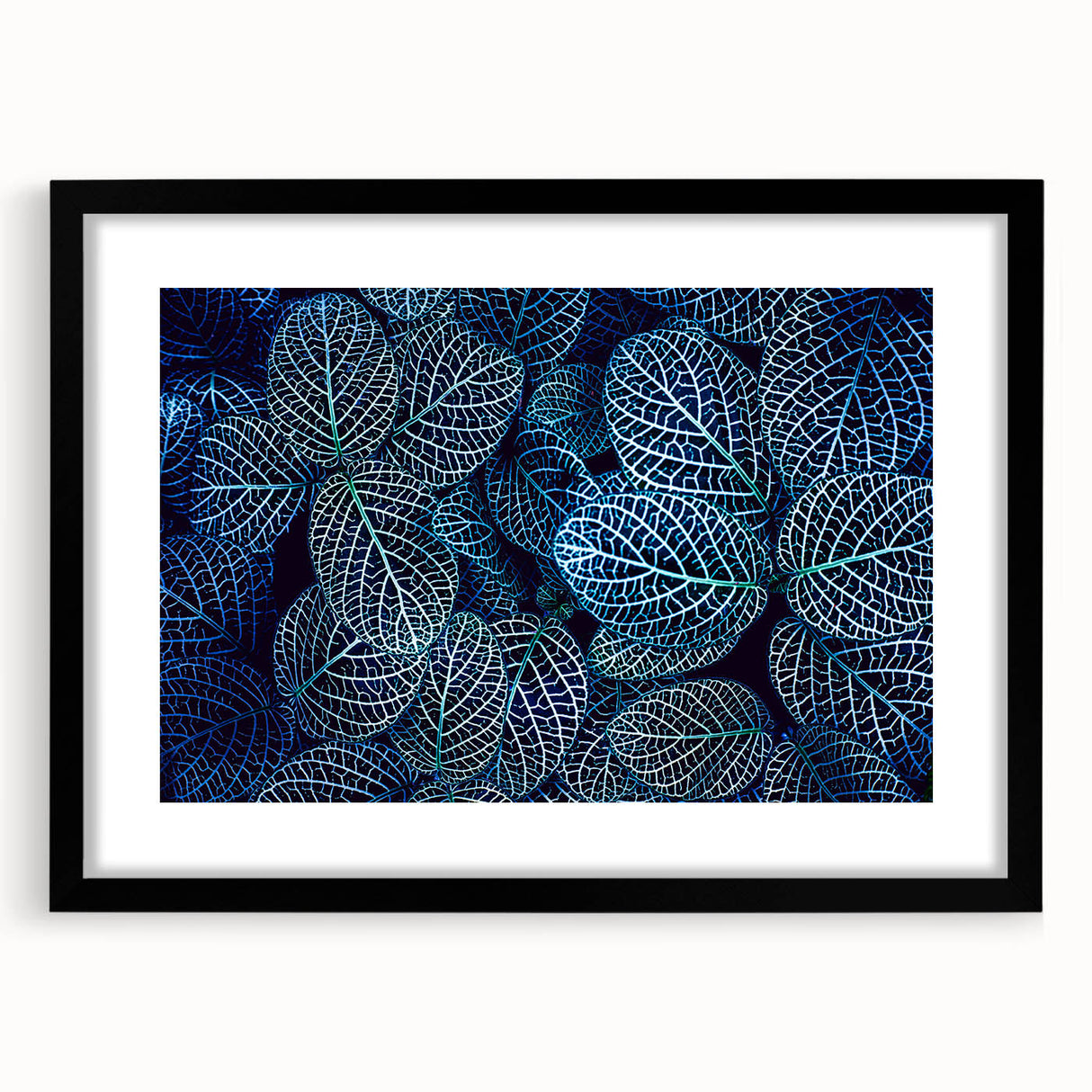 Colorful abstract art print of textured leaves, in a black frame with mat, ideal for living room decor.