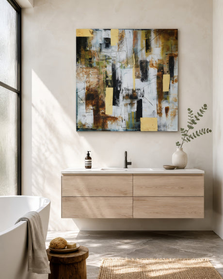 Textured abstract painting in earthy green, brown and gold hues hung over an oak floating vanity in a light bathroom.