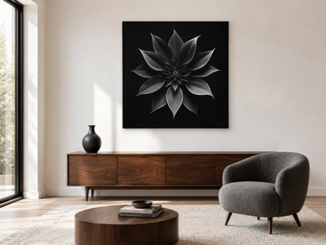Monochrome floral abstract canvas in black and gray above wooden sideboard with gray armchair in serene living room
