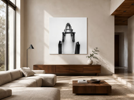 Monochrome fine-art photograph of wooden pier posts in fog, framed above a walnut console in a neutral modern living room