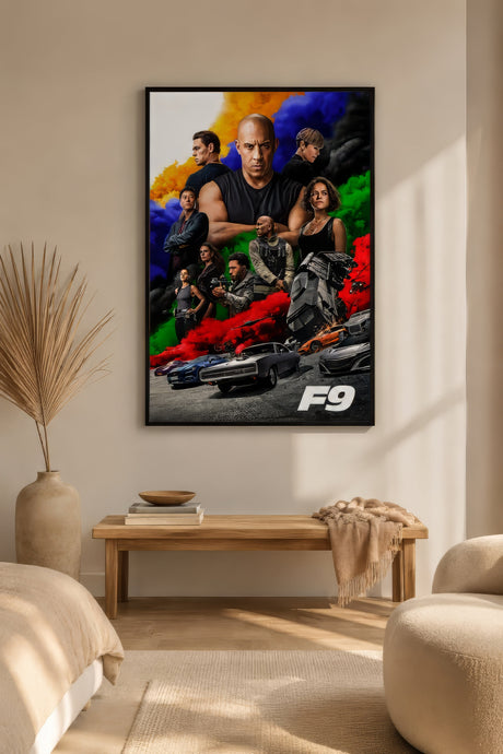 Black-framed F9 Fast and Furious movie poster with vivid multicolour smoke, hung on bare plaster wall above a wooden bench in a calm neutral living room.