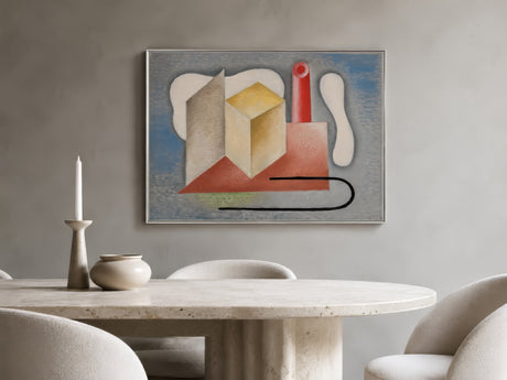 Contemporary cubist abstract canvas with cream cube, red and gray forms, framed above a travertine dining table in a warm minimalist room