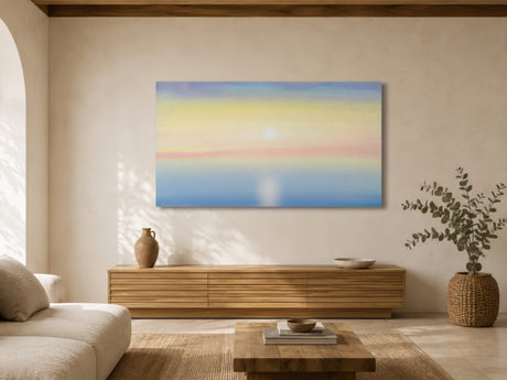 Minimalist pastel horizon artwork in blue, yellow and pink hues hung above oak sideboard in calm neutral living room.