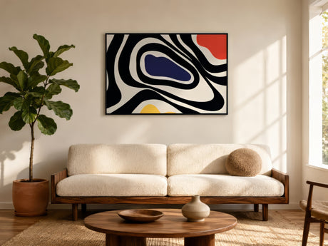 Bold abstract painting with swirling black, navy, red, and yellow shapes in black frame above cream boucle sofa in sunlit living room.