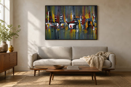 Multicolor abstract canvas in gray, red, and gold framed in black above a neutral linen sofa in a minimalist living room.