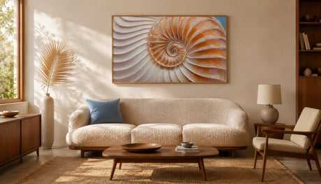 Textured nautilus shell spiral canvas in amber and ivory, framed above a cream boucle sofa in a warm neutral living room.